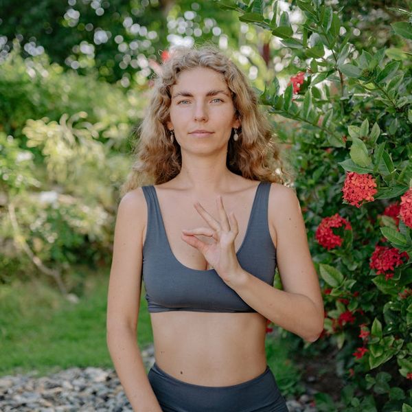 Woman meditating peacefully in a natural outdoor setting.